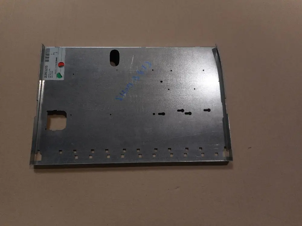 Metallisches Bauteil von Remeha, mit verschiedenen Ausschnitten und Löchern, dient möglicherweise als Kartenhalter oder Gehäuseteil. Oberfläche ist silbern und unbeschichtet.